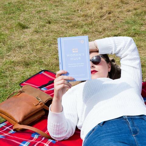 Woman reading book on grass