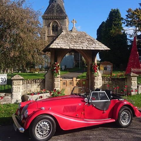 red classic Morgan car outside church
