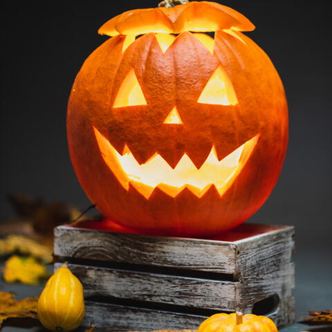 Pumpkin spookily carved on top of books