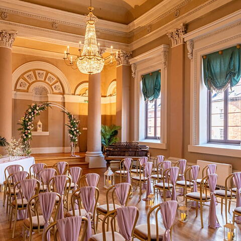 Large ballroom set up for a wedding ceremony with shades of gold
