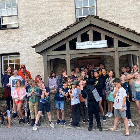 children gathered outside a community building