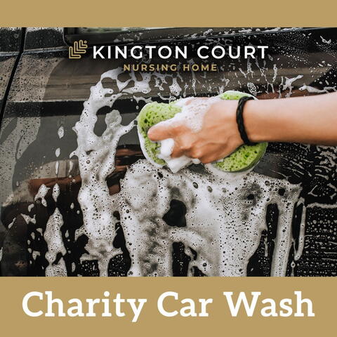 close up of hand holding sponge washing a car with soap suds