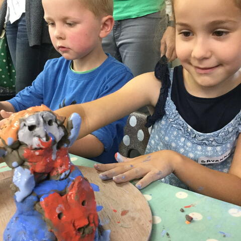 Children modelling clay creatures