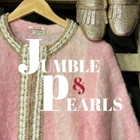 soft pink vintage top hanging on a wooden hanger