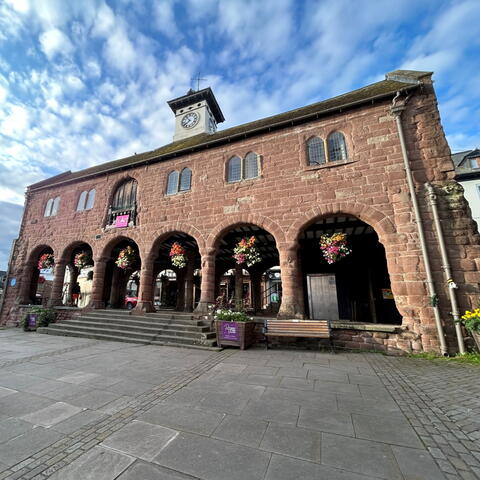 A picturesque Market House with stone arches and flowers 