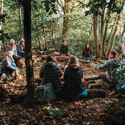 People sat in a circle in a forest