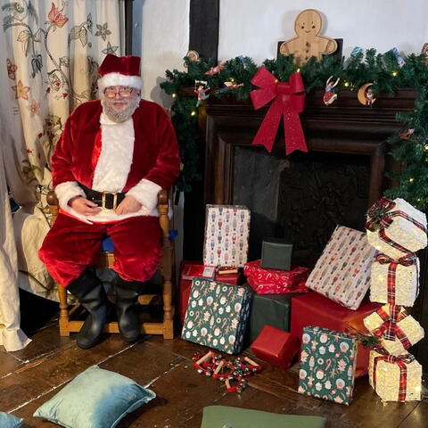 Meet Father Christmas at The Old House - poster with Santa in front of a fireplace