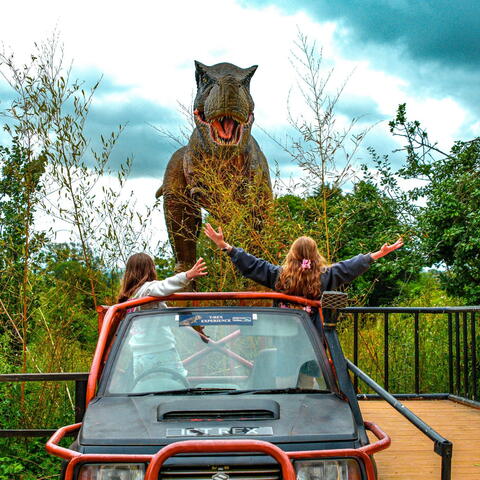 A dinosaur and a safari jeep