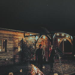 Couple keeping warm by campfire