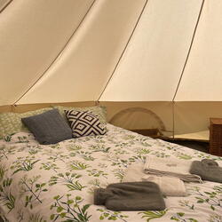 Double bed inside canvas bell tent